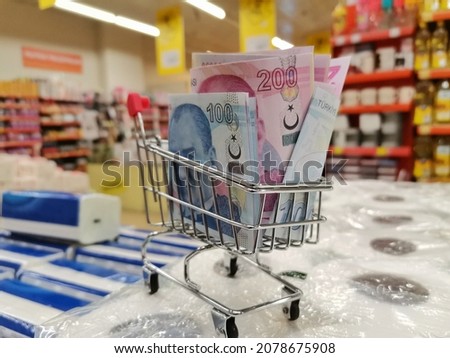 It's a grocery cart at the grocery store. Turkish Currency, which is undervayed. Expensive grocery shopping. Turkish Lira in a grocery cart