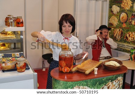 WARSAW - MARCH 26: Woman take out marinated cheese, from the jar - 14th International Food Service Trade Fair. March 26, 2010 in Warsaw, Poland.
