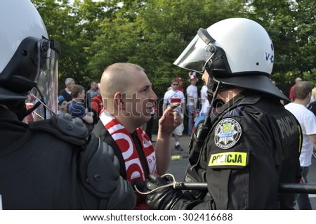 WARSAW, POLAND - JUNE 12, 2012 - Football fan talking to Riot Policeman during the UEFA EURO 2012 Group A match between Poland and Russia.