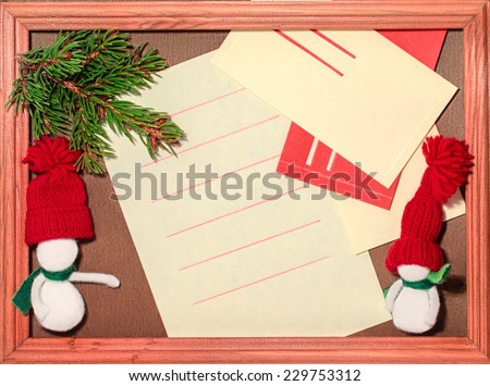 Blank sheet, envelope, snowman and Christmas tree  in a frame on the wooden background.