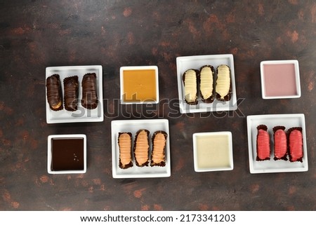 Eclairs at different color. Top view of the eclairs. Red, yellow, brown and orange eclairs. Delicious eclairs with different colored cream.   ストックフォト © 
