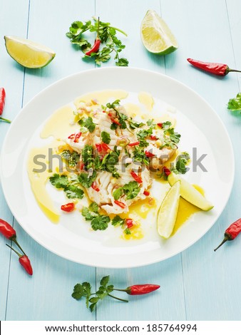 Steamed sea bass fillet with chili pepper and cilantro in olive and linseed oil. Shallow dof.