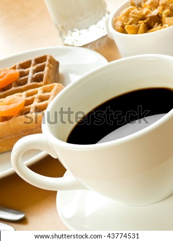 Coffee cup, wafers with apricots, cornflakes and milk. Shallow dof.
