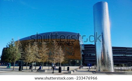 CARDIFF BAY, WALES, UK, NOVEMBER 11 2013: Showing the millenium centre with a water feature on a sunny day with people in the foreground