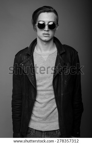 Fashionable  guy on a dark grey background in glasses