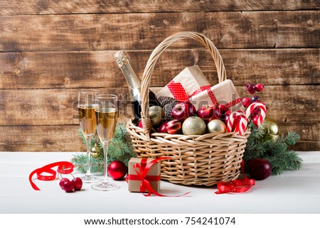 two glasses of champagne with christmas basket with bottle gifts with red satin ribbon - Christmas Basket Decorations two glasses of champagne with christmas basket with bottle gifts with red satin ribbon - Christmas Basket Decorations