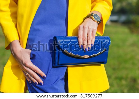 Young fashion woman hold blue handbag clutch