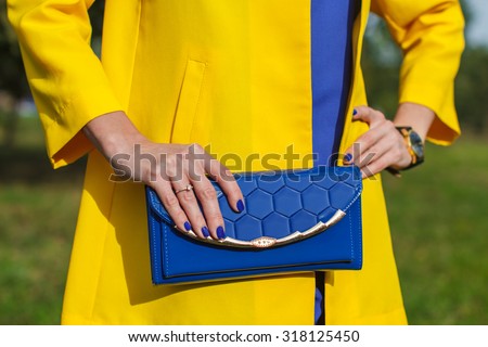 Young fashion woman hold blue handbag clutch