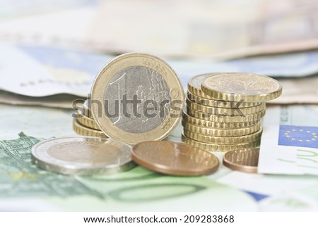 coins stacked in the foreground with notes and documents