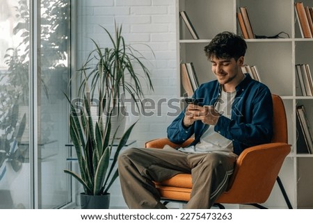 Similar – Image, Stock Photo Man using a mobile phone sitting on the grass with a sports bag