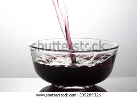 pouring black drink splash into glass on white background
