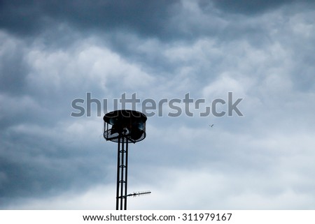 Gray and black storm clouds with speaker tower