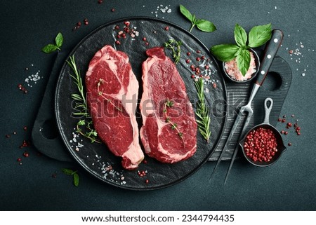 Similar – Image, Stock Photo Two raw marbled rib-eye steak on cutting board with rosemary, garlic and green pepper