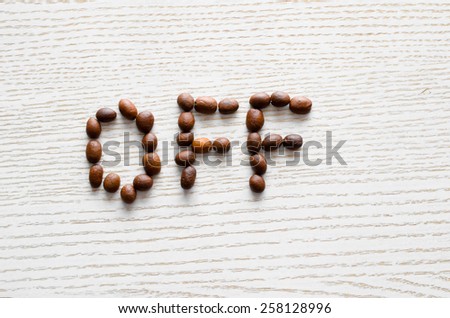 coffee beans on a white table sets out the inscription off