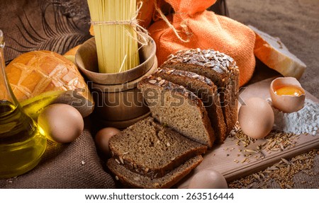 still life of bread and millet in old style on a linen cloth with a distinct texture. The figure also oil and grain cereals and eggs.