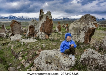 Foto Bild Auf Stein stehender Junge mit VR-Brille gegen Berg