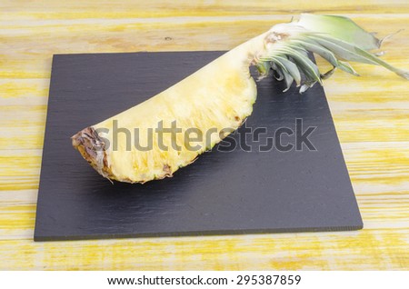 Quarter of Pineapple On slate dish, horizontal.