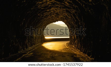 beautiful street in a rocky tunnel with an amazing sunset. 
this is a street near an italian lake.