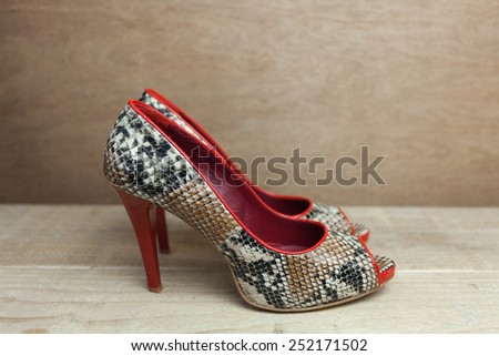 Snake leather woman shoes with red details close up