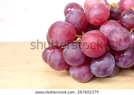 Bunch of red grapes on wooden table