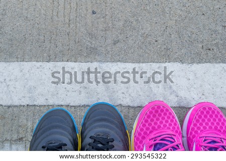 futsal shoes and pink running shoes on road background