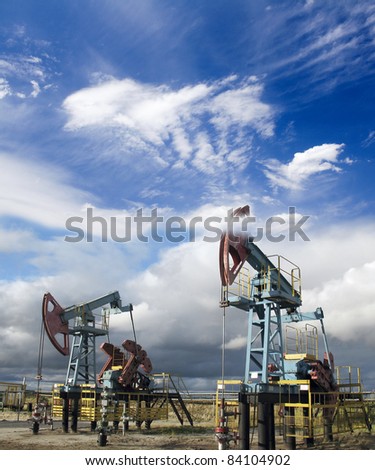 White clouds above oil pumps. Industrial scene