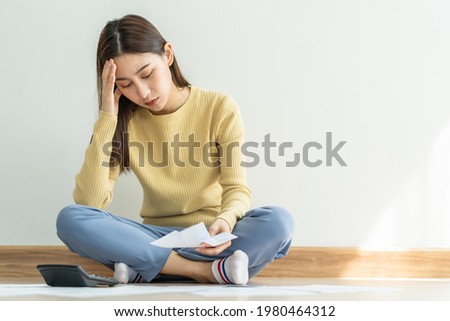 Financial owe asian woman, female sitting on floor home, stressed and confused by calculate expense from invoice or bill, have no money to pay, mortgage or loan. Debt, bankruptcy or bankrupt concept.