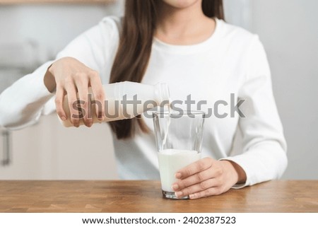 Similar – Image, Stock Photo Woman pouring fresh milk from bottle to enamel mug while having refreshment in garden