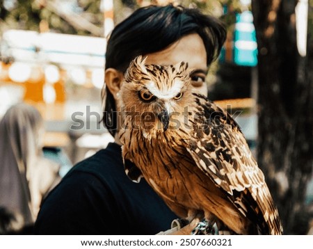 Similar – Man with owl head raises his finger