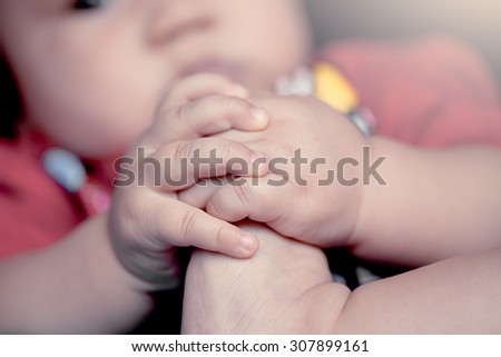 cute little boy hand hold own toe in soft color filter