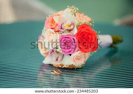 Pastel wedding bouquet with roses on blue glass table