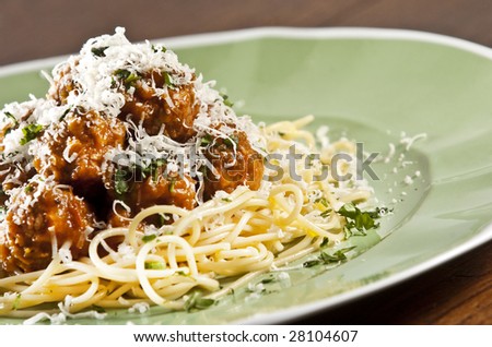 Spaghetti and meat balls with tomato sauce garnished with basil