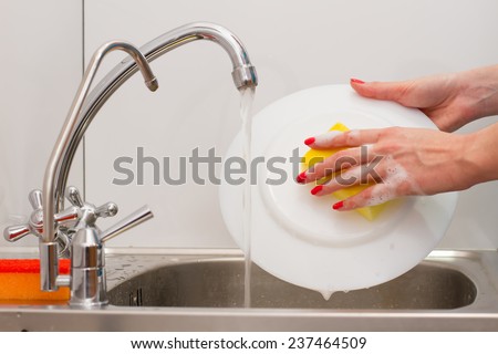 housewife with a nice manicure washes dishes