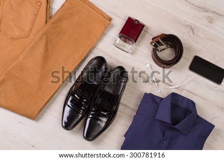 Collection of men\'s clothing and accessories on a wooden background.