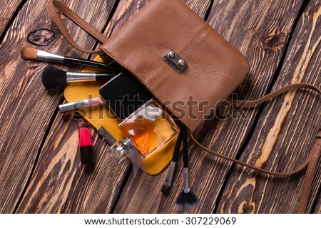 Fashion women\'s handbag. Open ladies handbag with scattered accessories.