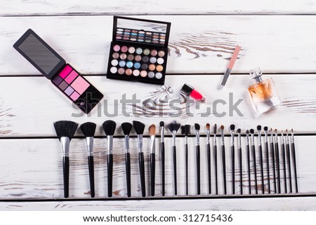 Set of cosmetics and makeup brushes on a wooden background. Fashion set.