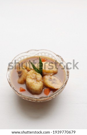 Kolak pisang ubi is Indonesian traditional dessert made of banana and sweet potato cooked with palm sugar and coocnut milk. Popular during ramadan. Isolated on white background Stok fotoğraf © 