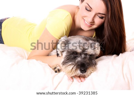 A pretty young woman in bed with her Miniature Schnauzer.