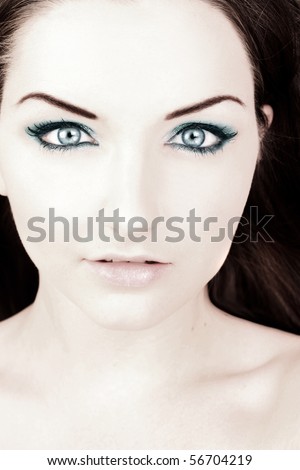 A close up beauty shot of a woman with blue make up and clear skin.
