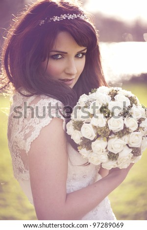 A beautiful bride looking at the camera outdoors.
