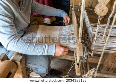 A woman weaver makes fabric on an old hand loom. Handmade woven products. Photo stock © 