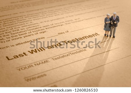 Last will and testament / legacy, inheritance or death tax concept : Miniature elder / old couple stands on a legal document form, depicts preparing to transfer properties to their heirs after death Imagine de stoc © 