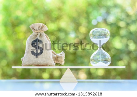 Time value of money, asset growth over time, financial concept : Dollar bags, sand clock or hourglass on a balance scale in equal position, depicts investment in long-term equity for more money growth 商業照片 © 