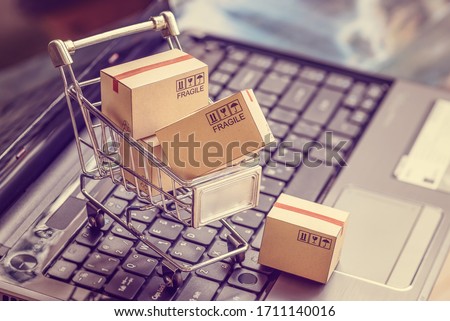 Online shopping  e-commerce and customer experience concept : Boxes with shopping cart on a laptop computer keyboard, depicts consumers  buyers buy or purchase goods and service from home or office ストックフォト © 