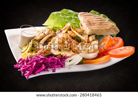 Chicken salad - chicken, tomato, sweet pepper, cucumbers, green salad and cheese on dark background