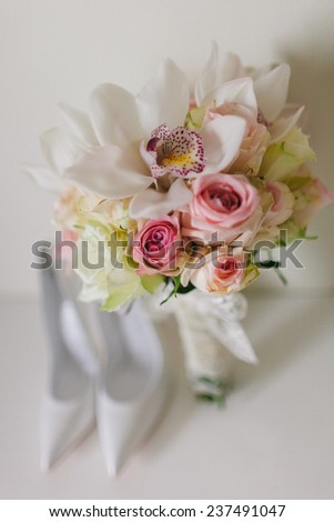 wedding bouquet  with orchids and roses and weddind bride\'s shoes on white background in fine art syle