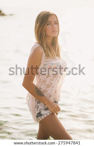 portrait of dreamy fashion woman in sea water in jeans shirts and light blouse