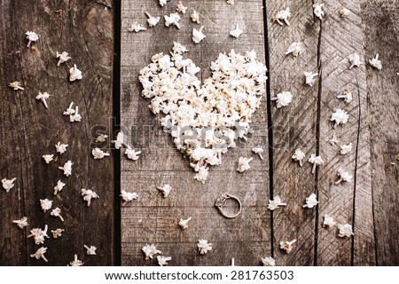 gentle beautiful white heart shape lilac flowers with proposal wedding ring on vintage wood table