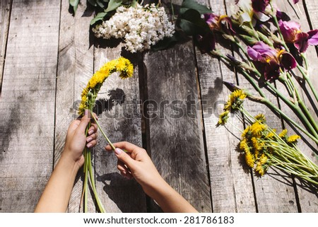 flower decoration of dandelions and irise lilac flowers handmade on vintage wood table