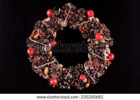 An original hand made christmas wreath on a black pine wood texture. Stock Image.